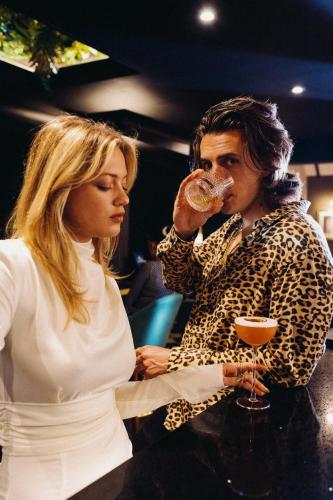 a woman standing next to a man drinking from a wine glass at The Chesterton Hotel in Bicester