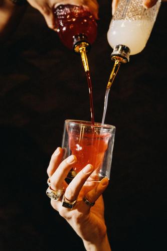 a person is pouring a drink into a glass at The Chesterton Hotel in Bicester