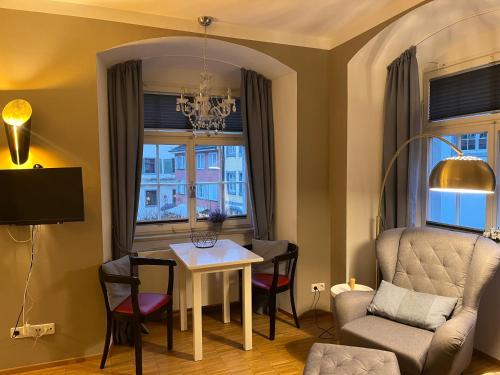 Una sala de estar con una mesa y sillas y una ventana. en Studio am Neuen Schloss Meersburg, en Meersburg
