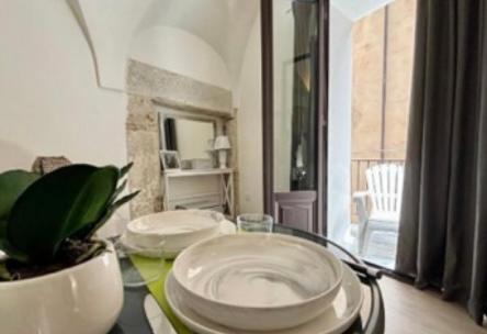 Una mesa con dos platos blancos y una planta encima. en Dimore D'amare, en Palermo