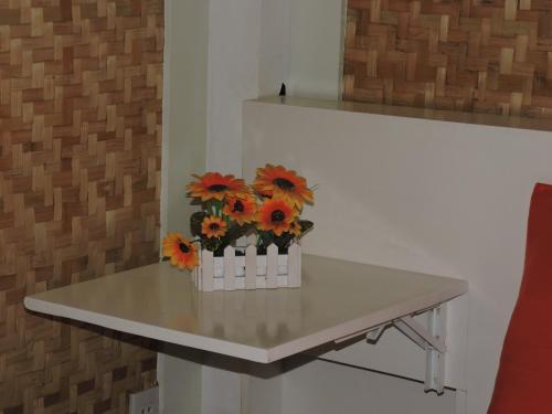 a table with a vase of orange flowers on it at Orange Mangrove Pension House by SMS Hospitality in Puerto Princesa City
