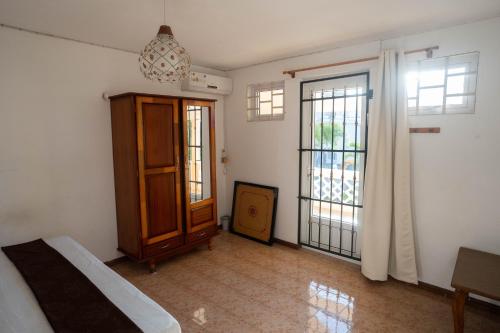 a room with a bed and a cabinet and windows at Private Villa & Pool, steps from the Beach in Flic-en-Flac