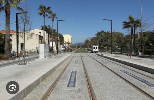 un train sur les pistes d'une rue bordée de palmiers dans l'établissement Studio proche de la mer, à Nice