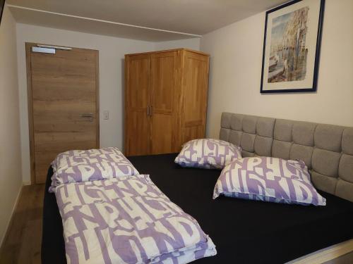 a bedroom with a bed and two pillows on it at Hotel Bruchsal Herz in Bruchsal