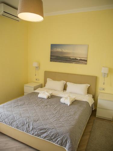 a bedroom with a bed with two towels on it at MIRAMAR Apart Hotel & SPA in Aktau
