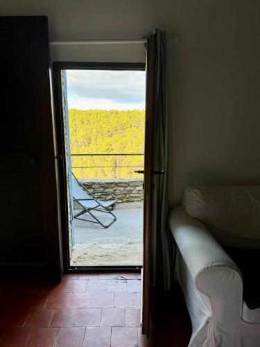 a bedroom with a door open to a balcony with a bed at La maison Haut-perché townhouse with view and jacuzzi in Saumane-de-Vaucluse