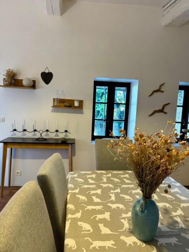 a dining room with a table with a vase on it at La maison Haut-perché townhouse with view and jacuzzi in Saumane-de-Vaucluse