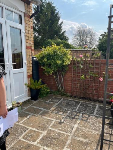 a woman standing in front of a brick fence at 2 bedroom Hidden Gem in Stamford with parking in Stamford
