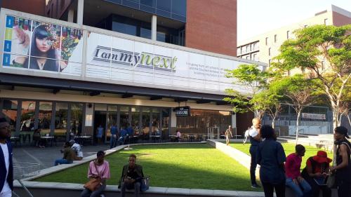 a group of people sitting in front of a building at The Franklin Luxury Condo with UPS for Wi-Fi in Johannesburg