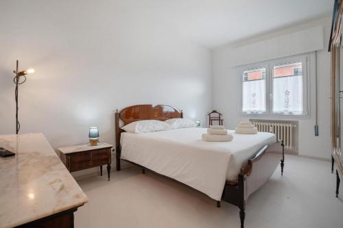 a bedroom with a bed with white sheets and a table at Appartamento Margherita in Venice