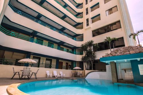 ein Hotel mit einem Pool und einem Gebäude in der Unterkunft Blue Bay Hotel in Salinas