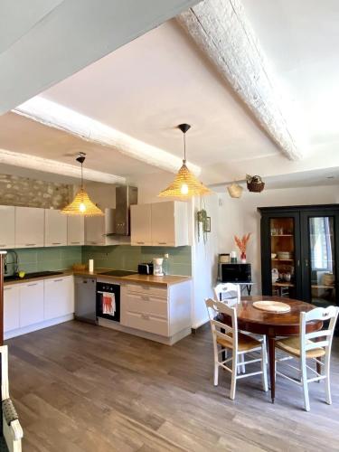 une cuisine et une salle à manger avec une table et des chaises dans l'établissement Villa les Volets Bleus an authentic house in the heart of the city center, à Fontaine-de-Vaucluse