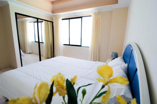 Un dormitorio con una cama con flores amarillas. en Blue Bay Hotel, en Salinas