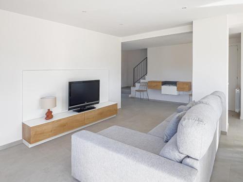 a living room with a couch and a tv at Els Majordoms - El Mont in Beuda