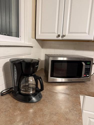 a coffee maker and a microwave on a kitchen counter at Gorgeous 3 BR Upper Unit Home in Buffalo