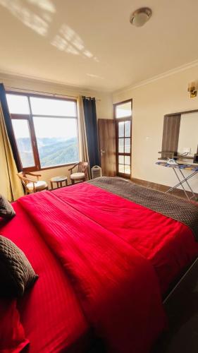 マショブラにあるPerfecto Staysの大きな窓付きのベッドルームの赤いベッド1台