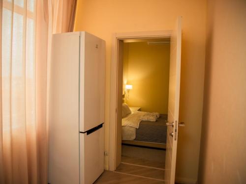 a bedroom with a bed and a door leading to a closet at MIRAMAR Apart Hotel & SPA in Aktau