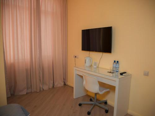 a room with a desk with a television and a chair at MIRAMAR Apart Hotel & SPA in Aktau