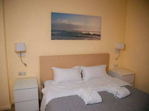 a bedroom with a bed with white sheets and pillows at MIRAMAR Apart Hotel & SPA in Aktau