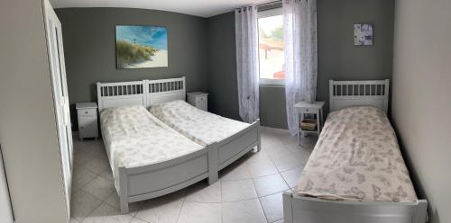 sypialnia z dwoma łóżkami i oknem w obiekcie Apartmani Starcevic w mieście Vir