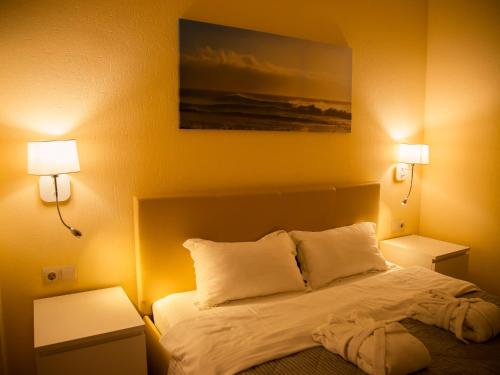 a bedroom with a bed with two lights on it at MIRAMAR Apart Hotel & SPA in Aktau