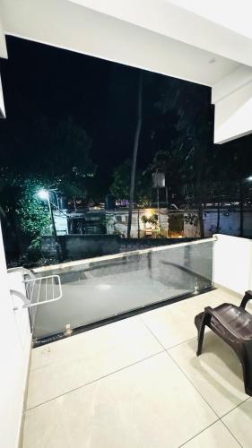 a black bench sitting on top of a balcony at night at Coastal Bliss Appartments in Varkala