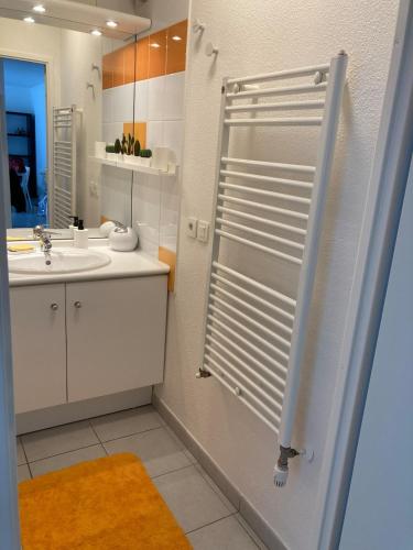 une salle de bain blanche avec une douche et un lavabo dans l'établissement Entre Médoc et Atlantique, 3 étoiles, calme en plein centre-ville, à Saint-Médard-en-Jalles