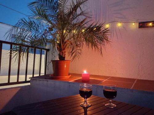 two glasses of wine and a candle on a table at Número 55 in Órgiva