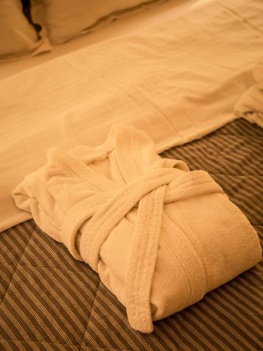 a white towel is sitting on a bed at MIRAMAR Apart Hotel & SPA in Aktau