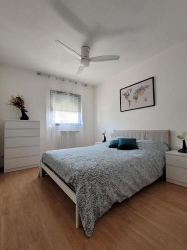 une chambre avec un lit et un ventilateur de plafond dans l'établissement Entre Médoc et Atlantique, 3 étoiles, calme en plein centre-ville, à Saint-Médard-en-Jalles