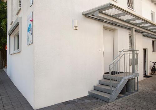 a white building with a staircase next to a door at Charmante Ferienwohnung in bester Lage in Feldkirch