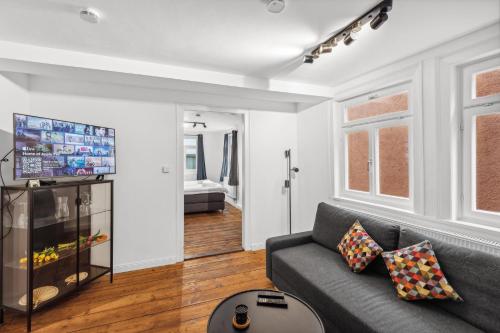 a living room with a couch and a tv at Residenz im historischen Zentrum - Aalen Apartments & Suites in Aalen
