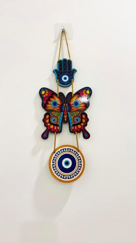 a butterfly ornament hanging on a white wall at Coastal Bliss Appartments in Varkala
