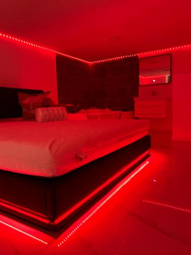 ein Schlafzimmer mit einem Bett mit roter Beleuchtung in der Unterkunft Love room in Camaret-sur-Aigues