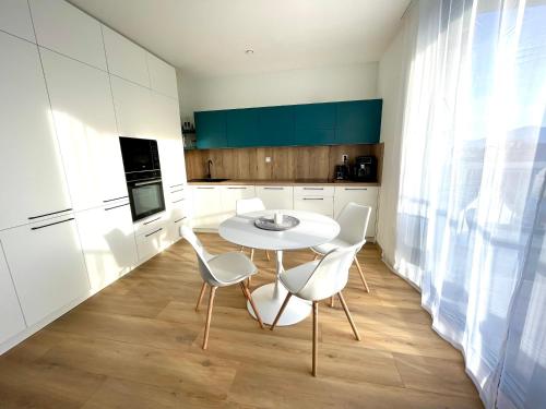 cocina con mesa blanca y sillas en una habitación en Urban CARTA II apartment, en Liptovský Mikuláš