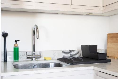 a kitchen with a sink and a counter top at 1Bed Gem, Quick Access to Windsor, Central London in Slough