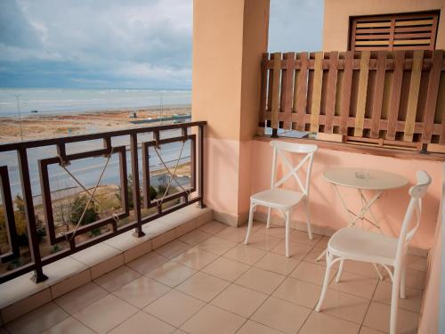 a balcony with a table and chairs and a view of the ocean at MIRAMAR Apart Hotel & SPA in Aktau