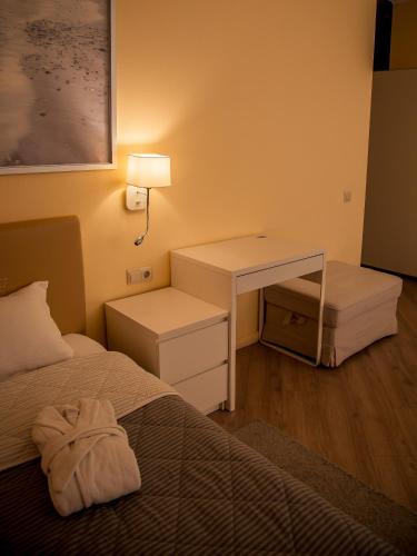 a hotel room with a bed and a desk and a bed at MIRAMAR Apart Hotel & SPA in Aktau