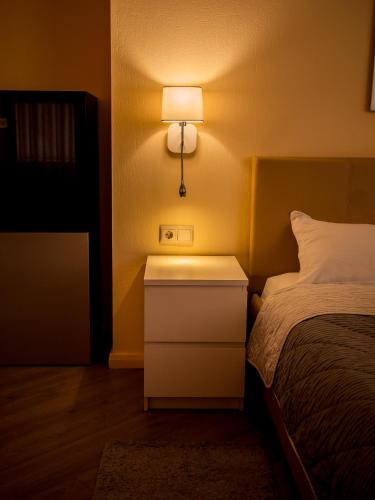 a bedroom with a bed and a nightstand with a lamp at MIRAMAR Apart Hotel & SPA in Aktau