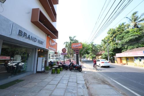 eine Stadtstraße mit einem Gebäude und eine Straße mit einem Geschäft in der Unterkunft Hotel StayInn in Kozhikode