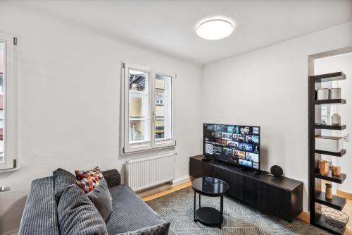 a living room with a couch and a flat screen tv at Residenz im historischen Zentrum - Aalen Apartments & Suites in Aalen