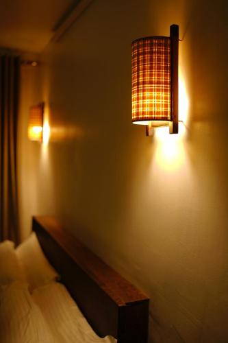 a bedroom with a bed and a lamp on the wall at Bamboo Grove in Mānantoddy