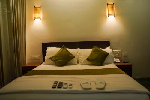 a bedroom with a bed with two remote controls on it at Bamboo Grove in Mānantoddy