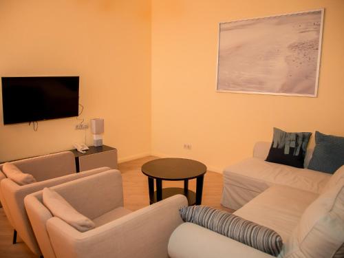 a living room with two couches and a flat screen tv at MIRAMAR Apart Hotel & SPA in Aktau