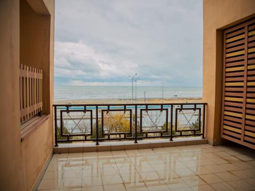 a room with a balcony with a view of the ocean at MIRAMAR Apart Hotel & SPA in Aktau