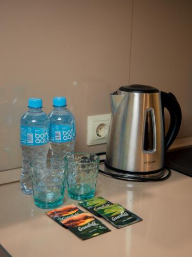 two bottles of water and glasses on a counter at MIRAMAR Apart Hotel & SPA in Aktau