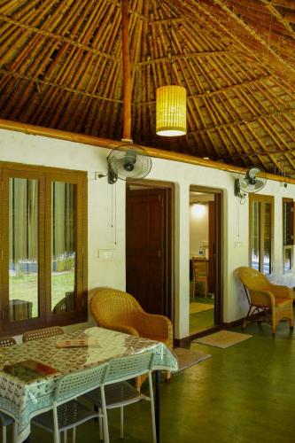 a room with a table and chairs and a ceiling at Bamboo Grove in Mānantoddy