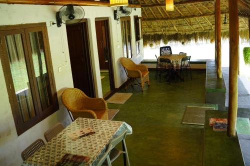 a room with tables and chairs in a building at Bamboo Grove in Mānantoddy