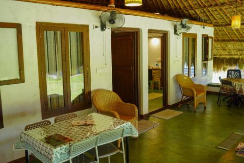 a dining room with a table and chairs and a room with a table and chairs at Bamboo Grove in Mānantoddy
