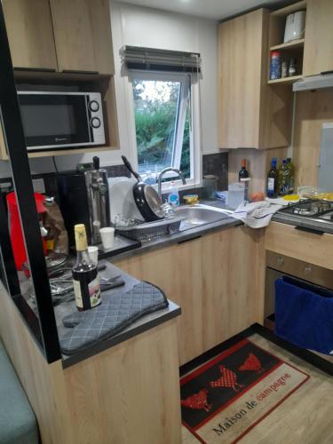 a kitchen with a sink and a counter top at Mobil Home Moderne de 40m2 TOUT CONFORT Camping SIBLU Les CHARMETTES 785 La Palmyre Les Mathes in Les Mathes